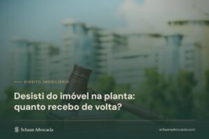 Martelo de juiz sobre mesa com prédios ao fundo, sobre a chamada Desisti do imóvel na planta: quanto recebo de volta?