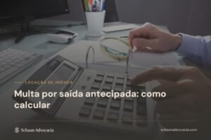 Mão operando calculadora sobre documentos, ao lado de teclado e lupa
